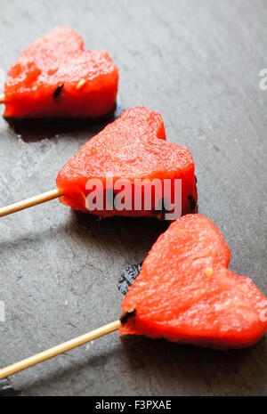 Wassermelone-Pops. Wassermelone-Scheiben in Herz-Form-Stücke schneiden. Stockfoto