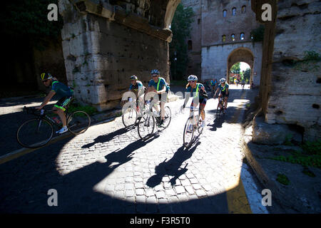 Rom, Italien. 11. Oktober 2015. Radfahrer fahren, vorbei an einem römischen Bogen entlang der antiken Via Appia während der historischen Radsport-Event "Granfondo Campagnolo Rom" in Rom, Italien, am 11. Oktober 2015. Die Veranstaltung lockte 5200 Radfahrer aus 40 Ländern und Regionen. Radfahrer gestartet vom Kolosseum entfernt, Symbol der ewigen Stadt, Radfahren zu historischen Sehenswürdigkeiten im antiken Rom, des Flusses Tiber und Venedig Platz, und reiste zu den römischen Hügeln. Schließlich fuhren sie vorbei an den Pflastersteinen der antiken Via Appia, die Ziellinie zu überqueren. Bildnachweis: Jin Yu/Xinhua/Alamy Live-Nachrichten Stockfoto