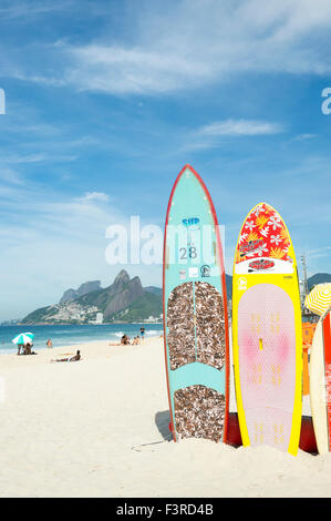 RIO DE JANEIRO, Brasilien - 22. März 2015: Bunte Stand-up Paddle Surfboards stehen aufgereiht am Strand von Arpoador. Stockfoto