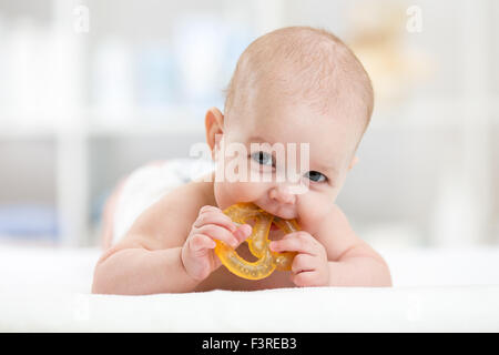 Babymädchen liegend auf Bauch weared Windel mit Beißring Stockfoto