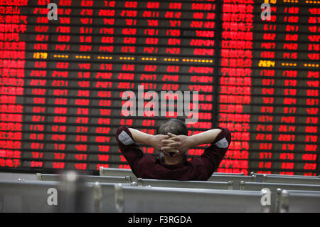 Ein Investor Watchs Schalttafel an einer Börse in Huaibei, Provinz Anhui, Ost-China am 12. Oktober 2015. Die CSI300-inde Stockfoto