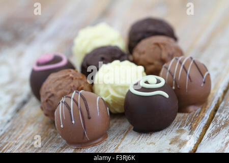Auswahl von weiß, Milch und dunklen Schokoladen und Pralinen auf rustikalen Holzoberfläche Stockfoto