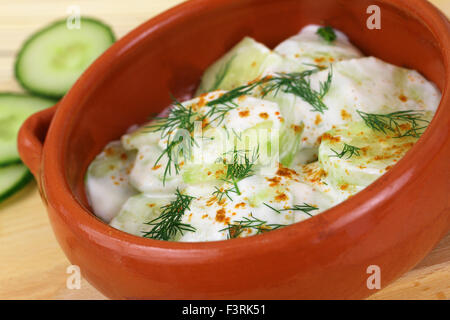 Gurke in saurer Sahne mit Paprika und frischem Dill in traditionellen Ton Schüssel Stockfoto