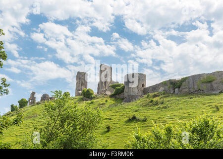 Die Hügel Ruinen von Corfe Castle in Dorset, Corfe, Südwest-England an einem sonnigen Tag mit weißen flauschigen Wolken und blauer Himmel Stockfoto