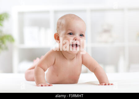 glückliches kleines Baby auf dem Bauch liegend und lächelnd Stockfoto