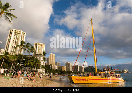 Hotels und Bootstouren direkt am Meer am Strand von Waikiki Strand. O' ahu. Hawaii. Menschen Touristen Sonnenanbeter Sonnenbaden Wohnkomplex Stockfoto