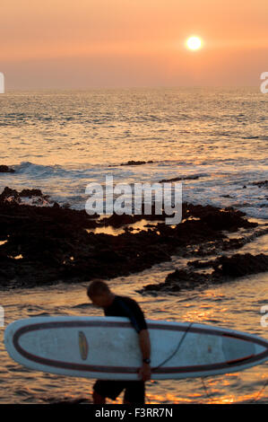 Surfer bei Sonnenuntergang am Strand in Waikoloa. Big Island. USA. Surfer in der Koralle und Lava Flanke Anaeho'omalu Bay auf Hawaii. WAIK Stockfoto