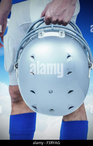 Zusammengesetztes Bild des Mittelteils des american Footballspieler übergibt seinen Helm Stockfoto