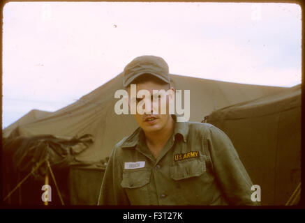 Ein amerikanischer Soldat der United States Army steht für ein Porträt neben einem Zelt am Nocken Rahn Bucht, eine Position des 1. logistische Befehls während des Vietnam-Krieges. Stockfoto