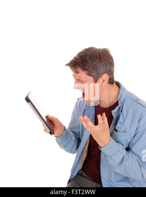 Ein junger Mann in eine blaue Jacke hält seinen Tablet und schrie es für weißen Hintergrund isoliert. Stockfoto