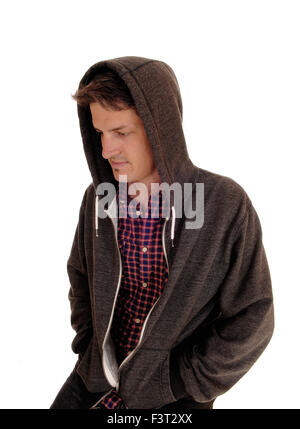 Ein hübscher junger Mann sitzt mit einen Pulli über den Kopf nach unten, für weißen Hintergrund isoliert. Stockfoto
