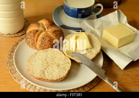 Weißbrot mit Butter und Milch, zubereitet auf einem Tisch Stockfoto