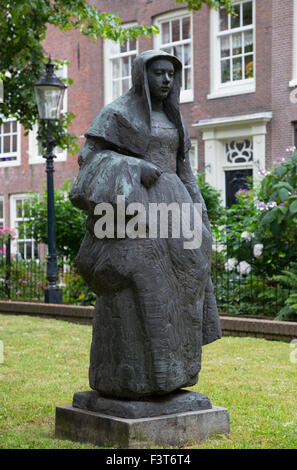 Statue von einer Begine im Hof des The Begijnhof, Amsterdam, Niederlande. Stockfoto