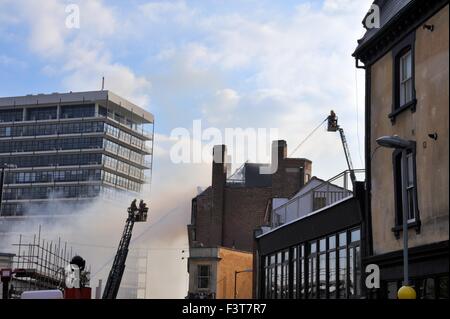 Bristol, UK. 12. Oktober 2015. Ein Großbrand begann ca. 13:00 h im University of Bristol Studentenwohnheim, 33 Colston Straße, Bristol, England, 12. Oktober 2015, von Avon Feuer & Rettungsdienste mit zwei Plattenspieler Leiter Feuerwehrfahrzeuge und mehr als vier weitere Module in Angriff genommen. Die Lage ist zwischen der Colston Hall und Griffin Pub in der Nähe der Kreuzung der Colston und Trenchard Street und diese Straßen für Fahrzeuge und Fußgänger geschlossen worden. Das Feuer hat die gesamte Länge des Daches und obersten Etage vollständig zerstört. Bildnachweis: Charles Stirling/Alamy Live-Nachrichten Stockfoto