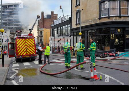 Bristol, UK. 12. Oktober 2015. Ein Großbrand begann ca. 13:00 h im University of Bristol Studentenwohnheim, 33 Colston Straße, Bristol, England, 12. Oktober 2015, von Avon Feuer & Rettungsdienste mit zwei Plattenspieler Leiter Feuerwehrfahrzeuge und mehr als vier weitere Module in Angriff genommen. Die Lage ist zwischen der Colston Hall und Griffin Pub in der Nähe der Kreuzung der Colston und Trenchard Street und diese Straßen für Fahrzeuge und Fußgänger geschlossen worden. Das Feuer hat die gesamte Länge des Daches und obersten Etage vollständig zerstört. Bildnachweis: Charles Stirling/Alamy Live-Nachrichten Stockfoto