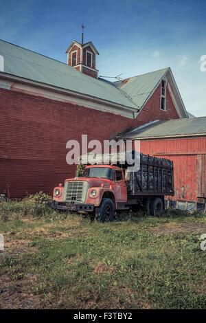 Einem alten roten Bauernhof LKW vor einer alten roten Scheune in Vermont. Stockfoto