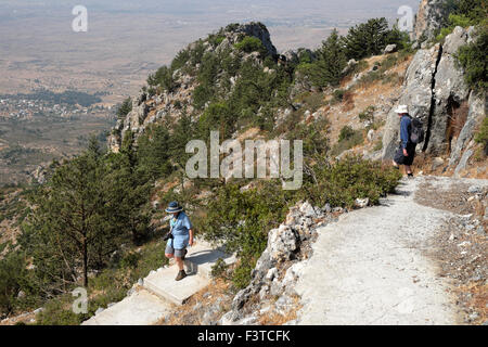 Mann und Frau Paar auf einem Wanderweg, der die Stufen von Buffavento Castle in Besparmak Kyrenia Mountains in Nordzypern KATHY DEWITT absteigt Stockfoto