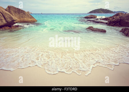 Vintage Stil schöne Natur des blauen Meeres Sand und weißen Wellen am kleinen Strand in der Nähe von den Felsen im Sommer auf der Insel Koh Miang Stockfoto