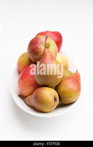 Äpfel und Birnen in einer weißen Schale. Stockfoto