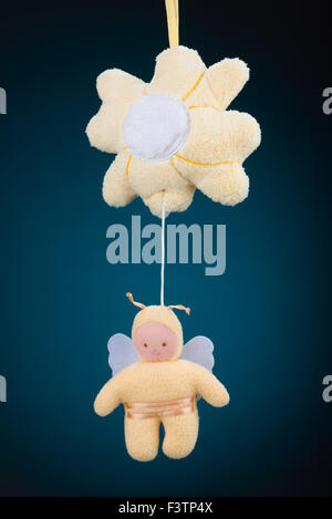 Eine gelbe Blume und Hummel Baby mobil auf einem blauen Hintergrund mit einem natürlichen schwarzen Vignette. Stockfoto