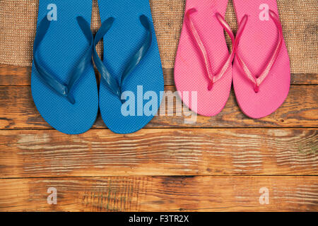 Hölzerne Grunge Hintergrund mit zwei Paar Flip-Flop Sandalen Stockfoto