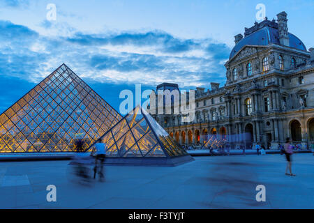Biker und Reisende gehen über den Hof des Louvre. Paris, Frankreich. August 2015. Stockfoto