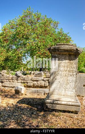 Eine griechische Inschrift an der antiken Stätte von Olympia in Griechenland. Die Inschrift hat antike griechische Buchstaben und befindet sich der Stockfoto