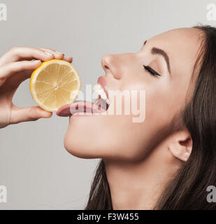 Porträt der Frau, die Förderung der gesunden Ernährung. Schöne junge Brünette Frau mit frischen in Scheiben geschnittenen Zitronen. Ernährung Gesundheit Stockfoto