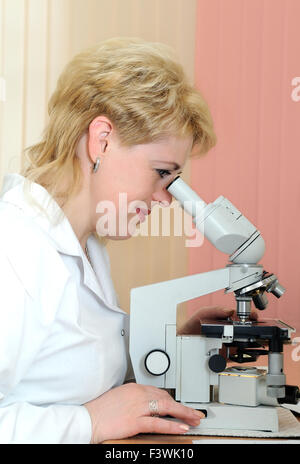 Wissenschaftlerin mit Mikroskop Stockfoto