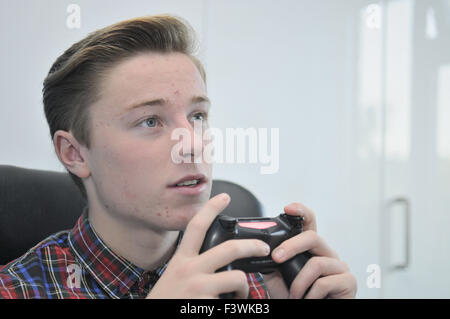 Teenager mit einem Sony Playstation4-controller Stockfoto