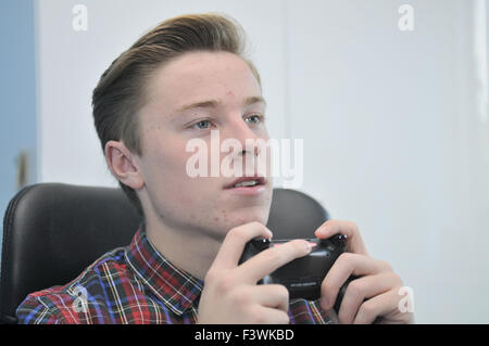 Teenager mit einem Sony Playstation4-controller Stockfoto