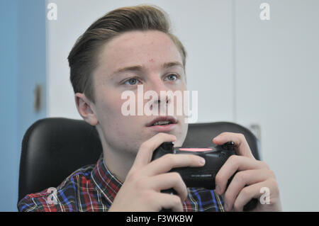 Teenager mit einem Sony Playstation4-controller Stockfoto