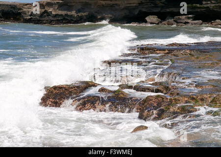 Ozean Wellen über die Felsen an der Küste Stockfoto