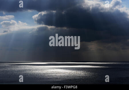 Brighton, Großbritannien. Sonnenstrahlen brechen durch die bedrohlichen dunklen Wolken, die sich vor dem Strand von Brighton bilden Stockfoto