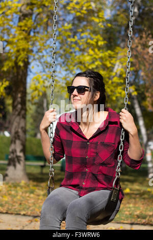 junge Frauen auf einer Schaukel im Herbst im park Stockfoto