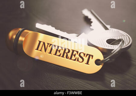 Interesse-Konzept. Tasten mit goldenen Schlüsselanhänger. Stockfoto