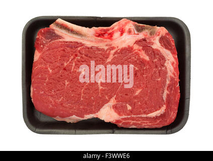 Draufsicht eines großen Knochens im Rib-Eye Steak auf einem schwarzen Metzger Tablett isoliert auf einem weißen Hintergrund. Stockfoto