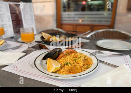 Paella auf der Platte im Straßencafé Stockfoto