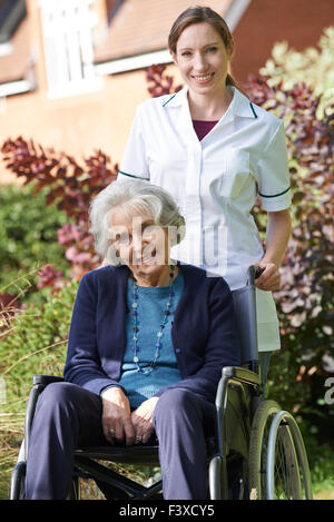 Porträt der Pflegeperson Senior Frau im Rollstuhl schieben Stockfoto