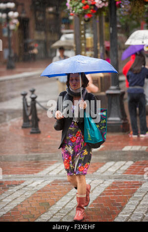 Frau zu Fuß in den Regen halten einen Regenschirm, Vancouver. Stockfoto