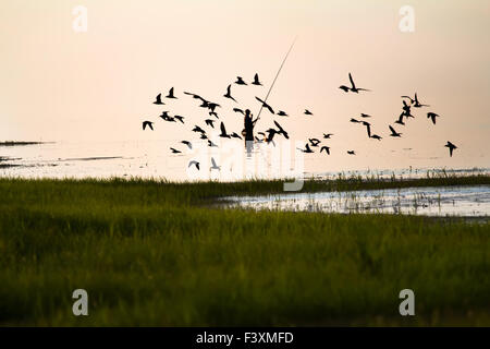 Fischer-Silhouette auf dem See Stockfoto