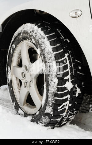 Nahaufnahme von einem Pkw-Reifen auf einer verschneiten Straße Stockfoto