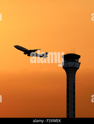 Air Traffic Control Tower mit ein startendes bei Sonnenuntergang. Flughafen Luton, UK. Stockfoto