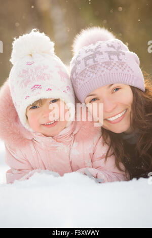 Glückliche Familie auf Schnee liegen Stockfoto