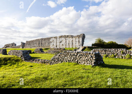 England, Richborough. Rutupiae. Römische Saxon Shore fort. 3. Jahrhundert Nordwand. Vordergrund, der Stein Stiftung Ruinen der Mansio. Blauer Himmel. Stockfoto