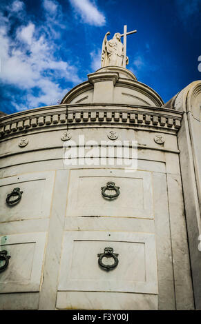 Engel mit Kreuz überragt die legendäre Krypten in der ältesten und berühmtesten St. Louis Nummer eins-Friedhof in New Orleans, LA Stockfoto