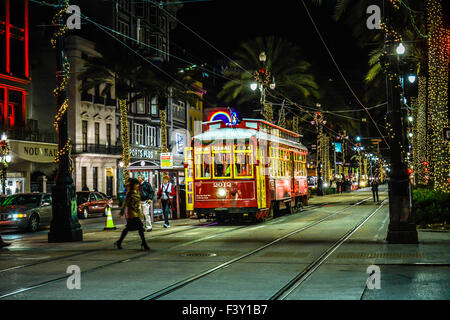 Der Kanal Straßenbahn bei Nacht unter den Neonröhren und Palm Tree Beleuchtung sorgt für ein festliches Ambiente in New Orleans, LA Stockfoto