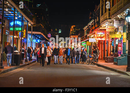 Die Menschen Sie feiern und Bummeln unter die Neonlichter auf berühmte Bourbon Street in der Nacht im French Quarter, New Orleans, LA Stockfoto