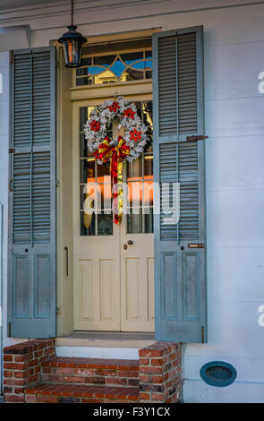 Creole Stadthaus Tür und Fensterläden mit einen geschmackvollen, charmanten Adventskranz im Bereich French Quarter von New Orleans, LA Stockfoto