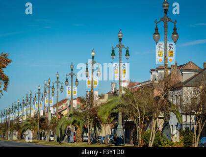 Sich wiederholende Muster der antiken Lampe post Linie Rampart Street mit Jazzfest Banner im Stadtteil Treme von New Orleans, LA Stockfoto